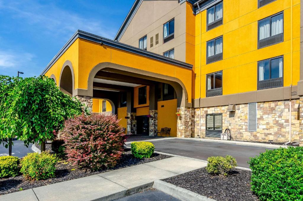 un grande edificio giallo con cespugli di fronte di Quality Inn & Suites ad Abingdon