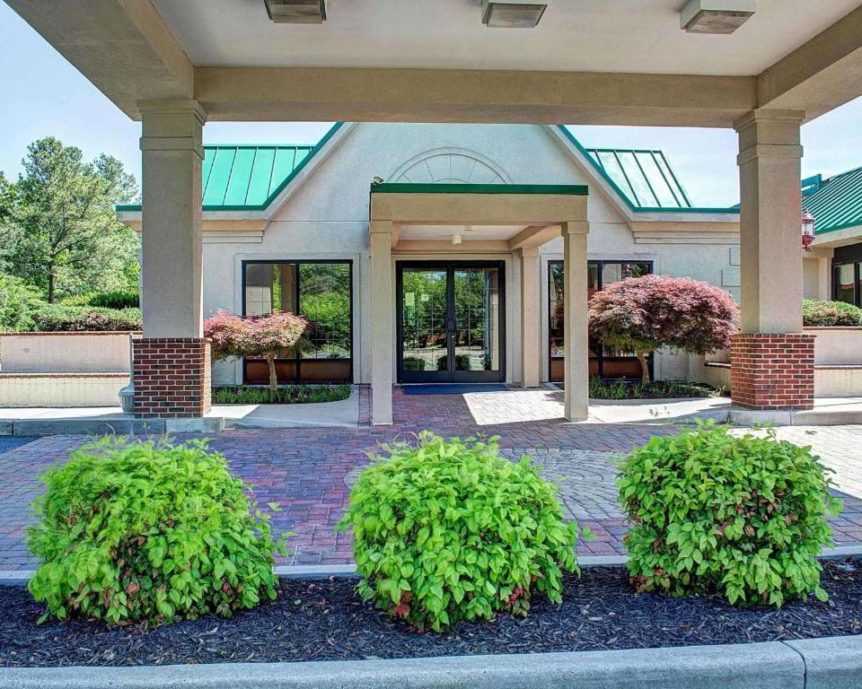 a building with two bushes in front of it at Quality Inn North in Richmond