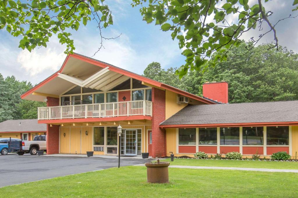 a large red building with a balcony in a parking lot at Econo Lodge in Manchester