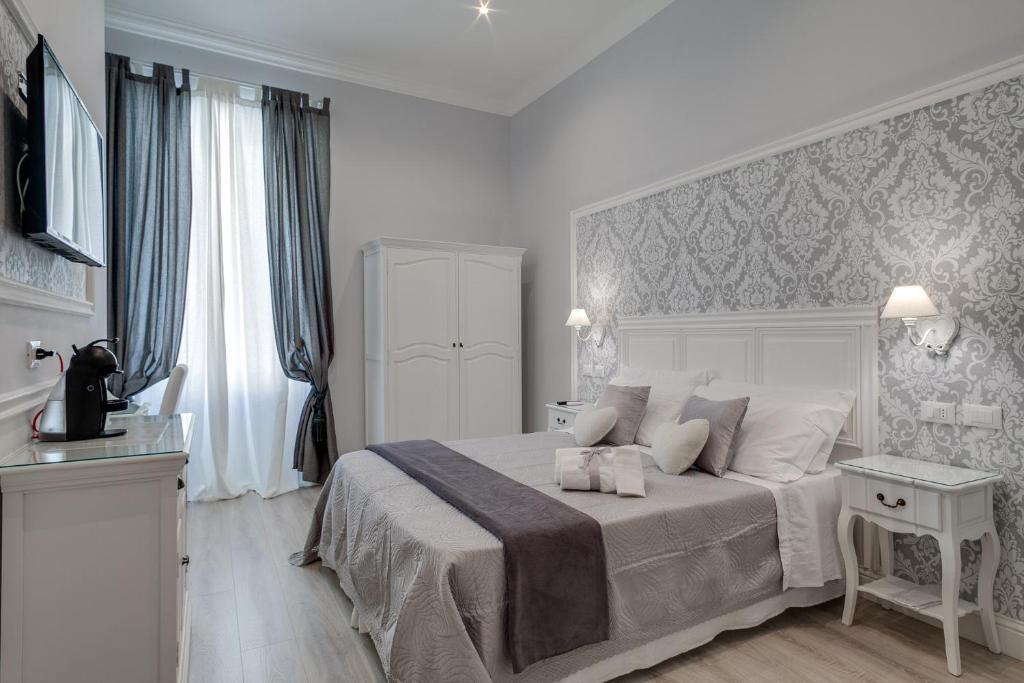 a white bedroom with a large bed and a window at Charme & Chic Luxury in Rome