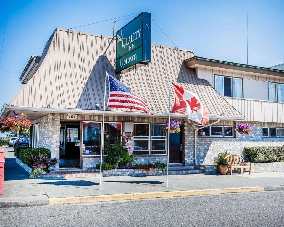Um restaurante com duas bandeiras americanas à frente. em Quality Inn Port Angeles - near Olympic National Park em Port Angeles