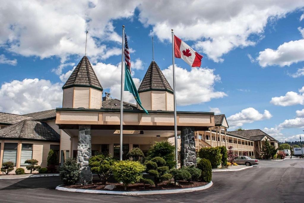 a hotel with two canadian flags on top of it at Quality Inn & Suites Fife Seattle in Fife