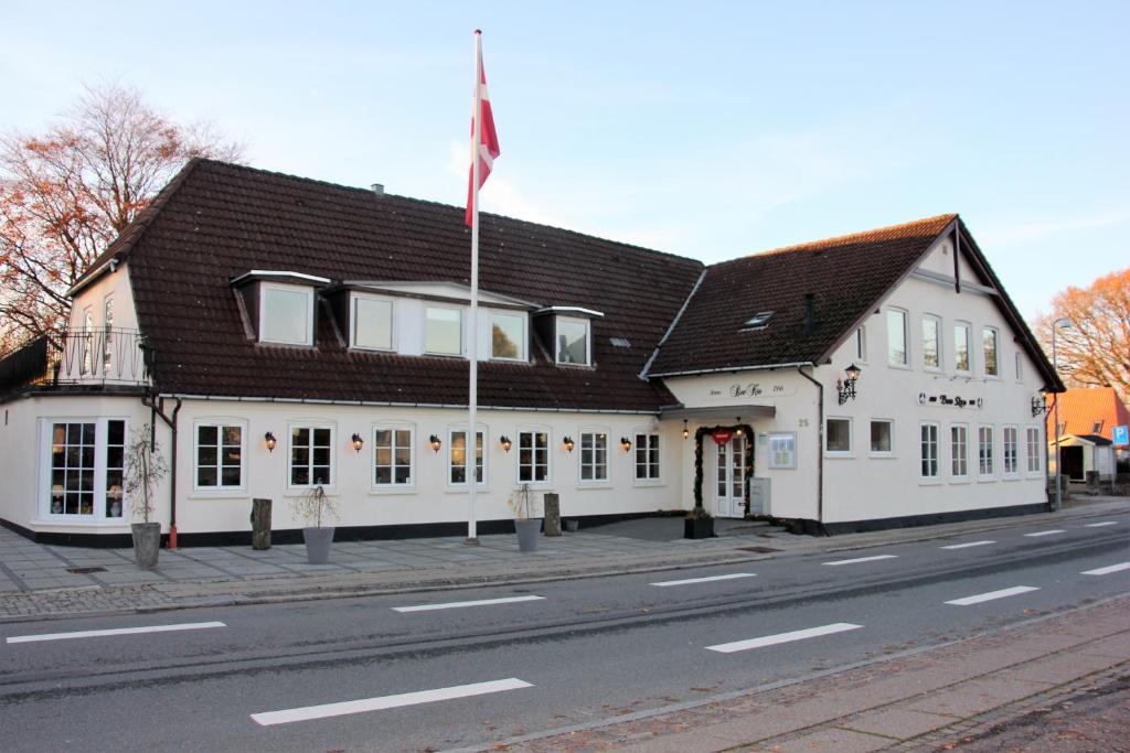 un gran edificio blanco con una bandera en una calle en Hotel Bov Kro en Padborg