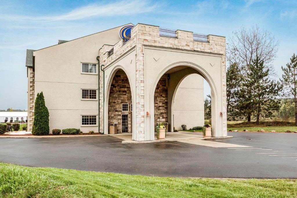 a building with an arch in a parking lot at Comfort Suites at Par 4 Resort in Waupaca