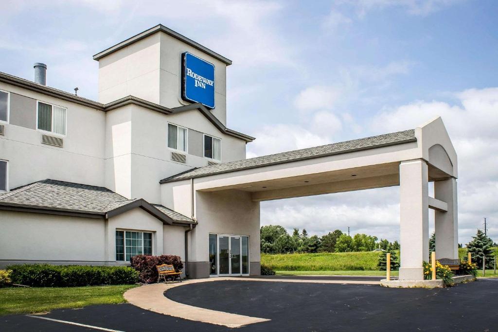 a large white building with a blue sign on it at Rodeway Inn Abbotsford in Abbotsford