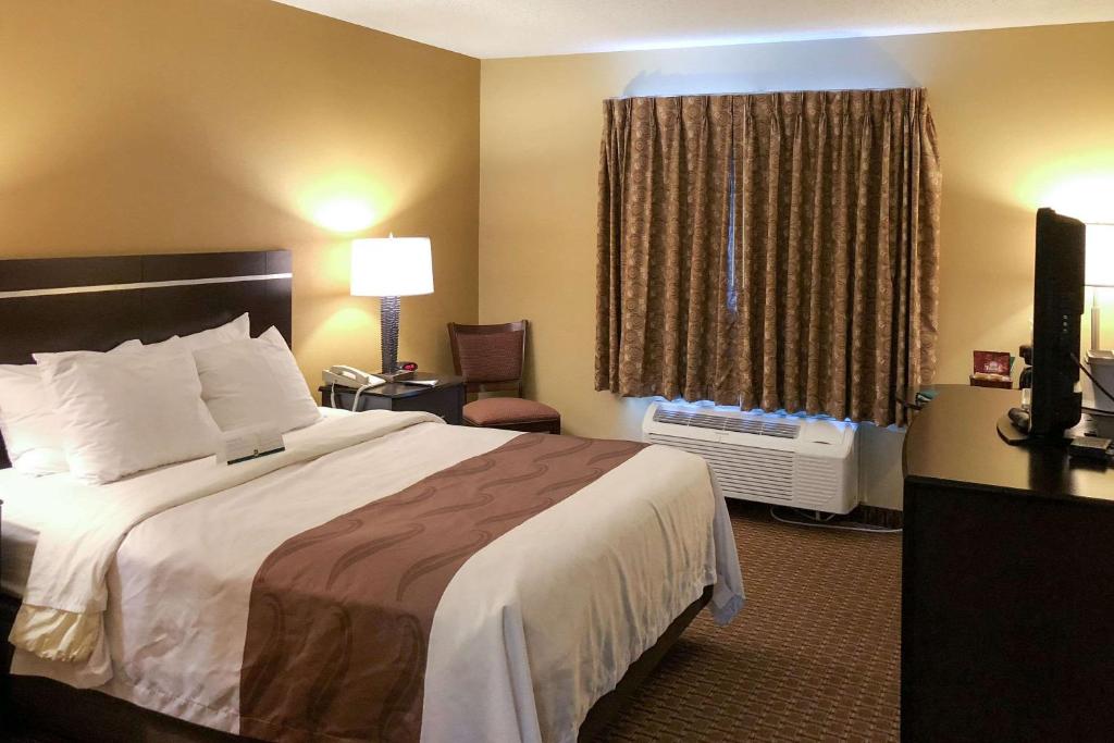 Quality Inn & Suites Sun Prairie Madison East في Sun Prairie: غرفه فندقيه بسرير ونافذه