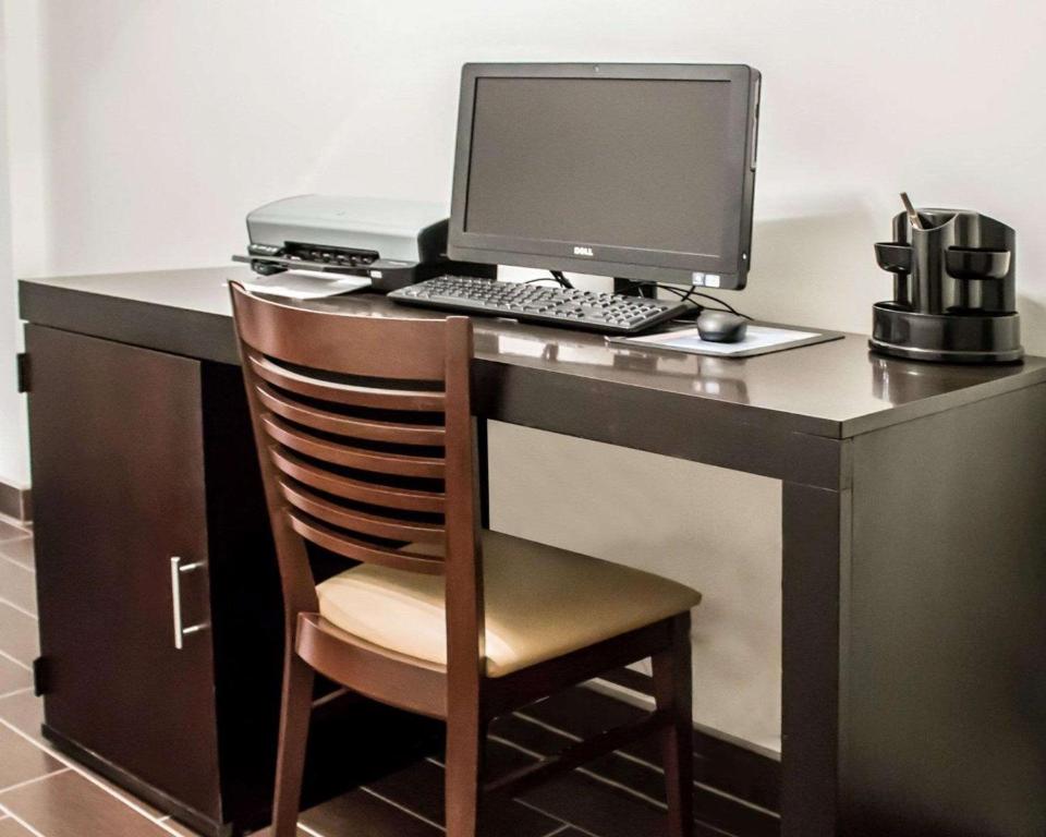 a desk with a computer monitor and a chair at Sleep Inn in Summersville