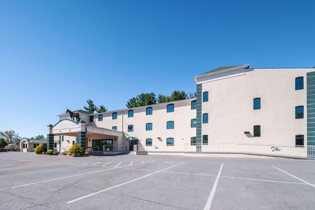 a large building with a parking lot in front of it at Rodeway Inn and Suites - Charles Town,WV in Charles Town