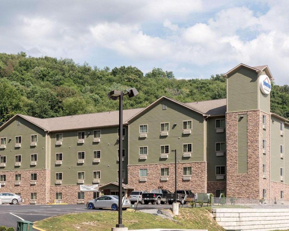a large building with a clock tower in a parking lot at Suburban Studios Morgantown in Morgantown