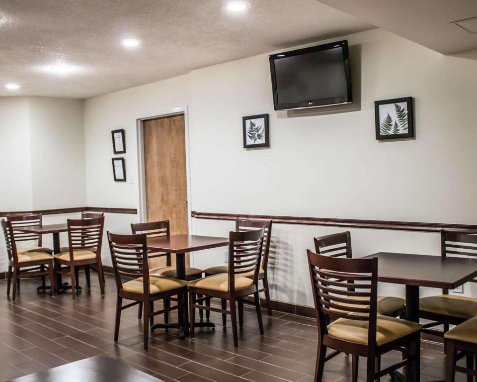 a dining room with tables and chairs and a flat screen tv at Sleep Inn in Summersville
