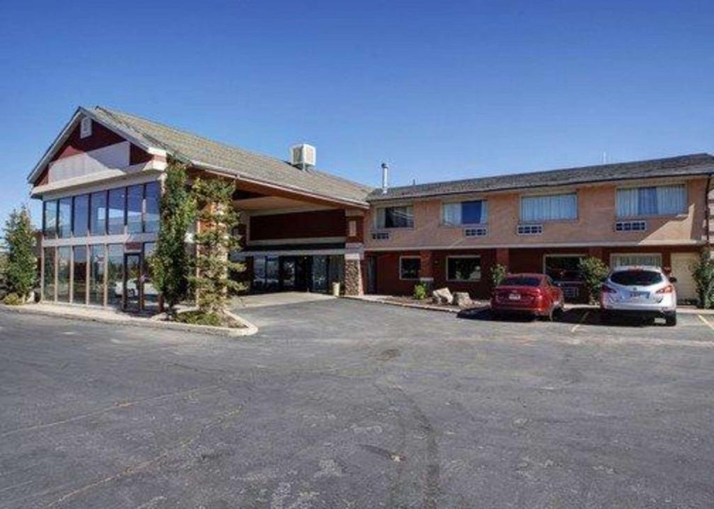 un grand bâtiment avec des voitures garées dans un parking dans l'établissement Quality Inn Evanston near Wyoming Downs, à Evanston