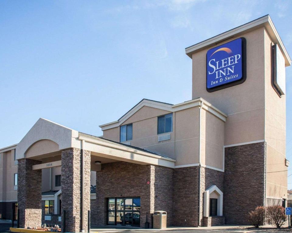 a building with a sign on the side of it at Sleep Inn & Suites Topeka West I-70 Wanamaker in Topeka