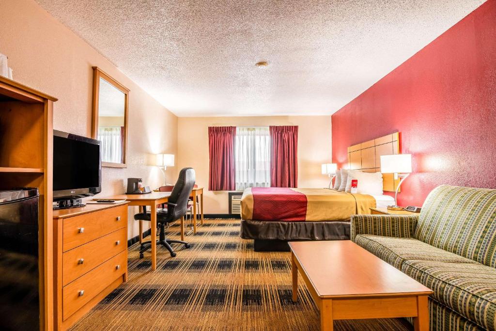 Cette chambre comprend un lit, un canapé et un bureau. dans l'établissement Econo Lodge Wanamaker, à Topeka