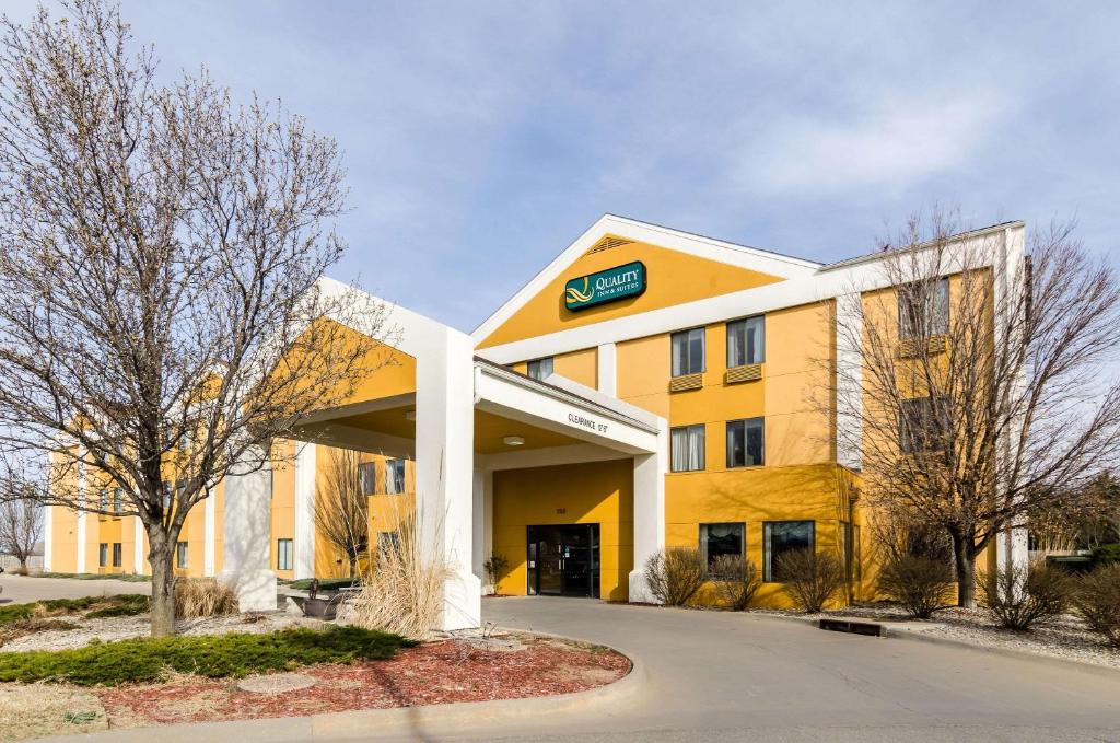 a yellow and white building with a sign on it at Quality Inn & Suites in Manhattan