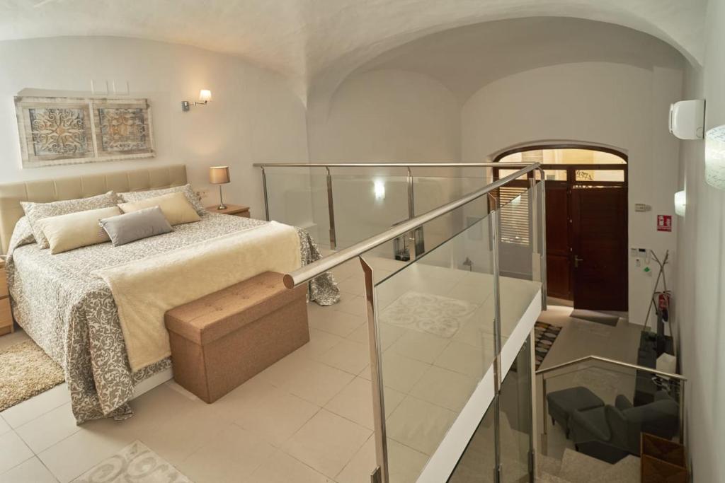 een slaapkamer met een bed en een glazen trap bij Apartamento Turístico Centro Monumental -- Caceres in Cáceres