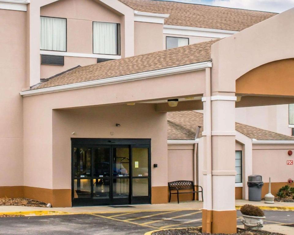 a building with a glass door in a parking lot at Sleep Inn in Louisville