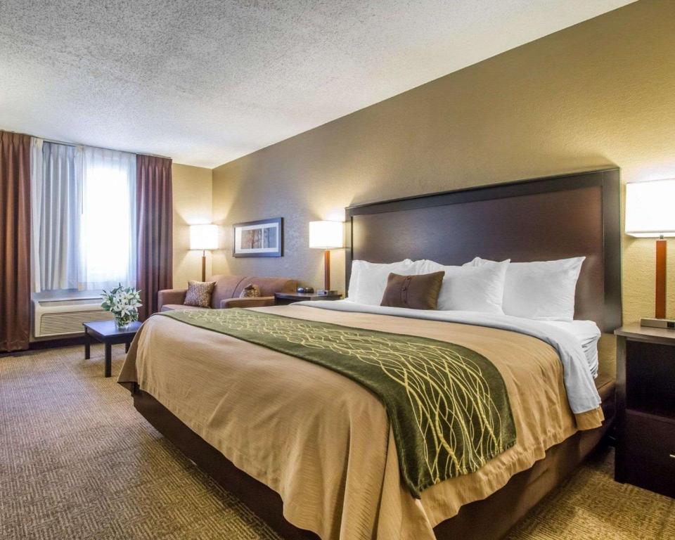 een hotelkamer met een groot bed met 2 lampen bij Quality Inn in Harlan