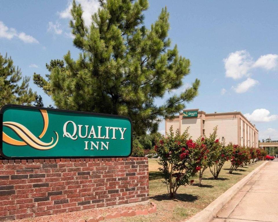 a sign for a quality inn in front of a tree at Quality Inn Shreveport in Shreveport