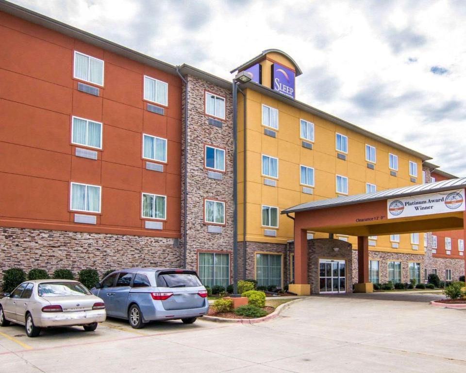 ein Hotel mit zwei Autos auf einem Parkplatz in der Unterkunft Sleep Inn & Suites I-20 in Shreveport