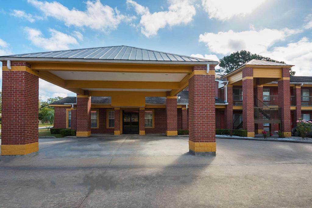 a large brick building with a metal roof at Quality Inn in DeRidder