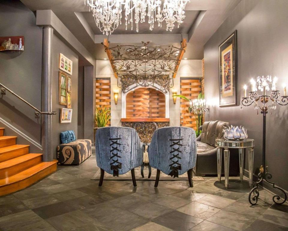 un salon avec des chaises bleues et un lustre dans l'établissement Bluegreen Vacations Club La Pension, à La Nouvelle-Orléans