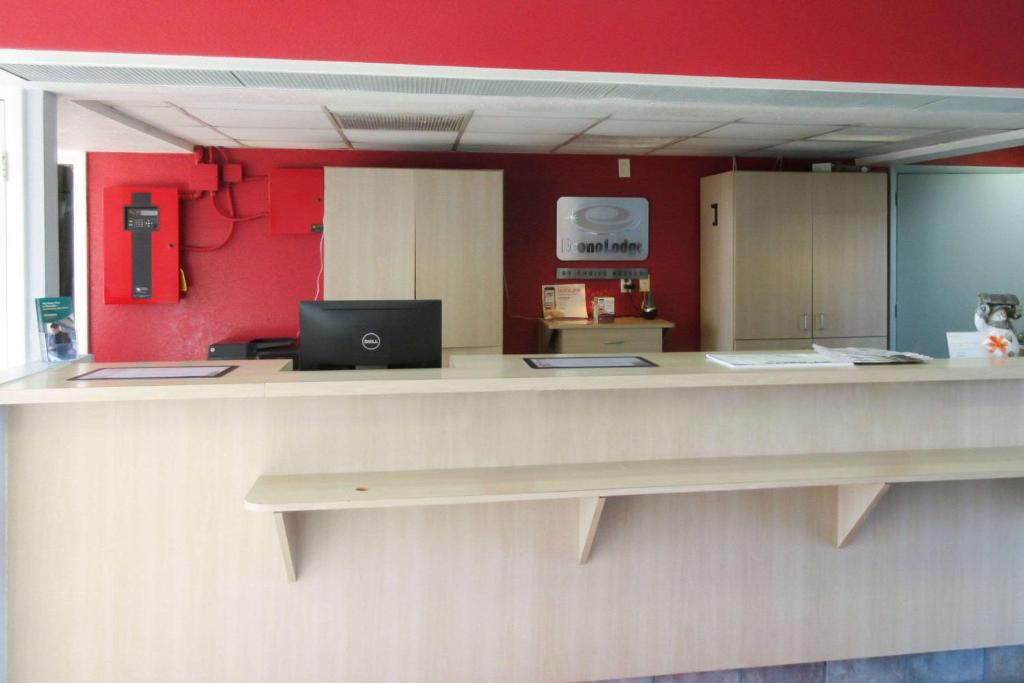 un bureau avec un comptoir avec un mur rouge dans l'établissement Econo Lodge Paducah West I-24, à Paducah