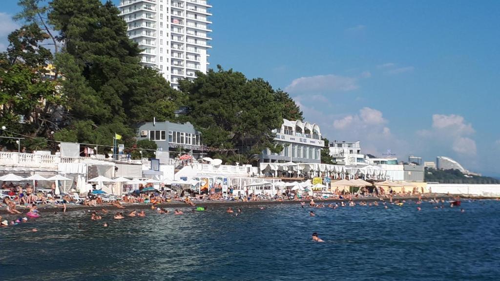 a group of people swimming in the water at a beach at Apartments ZHK Svetlana in Sochi