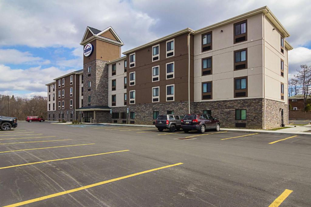 a parking lot in front of a building with a clock tower at Suburban Studios Monaca - Pittsburgh in Monaca