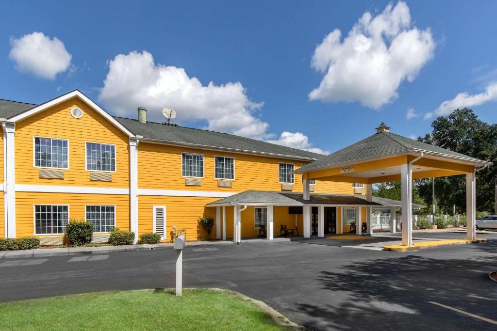 un edificio giallo con un parchimetro di fronte di Quality Inn a Kingstree