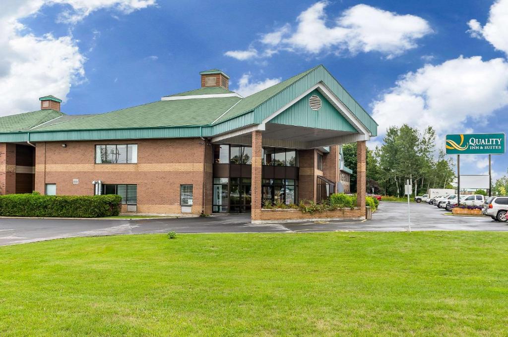 a building with a green roof and a parking lot at Quality Inn & Suites in Hawkesbury