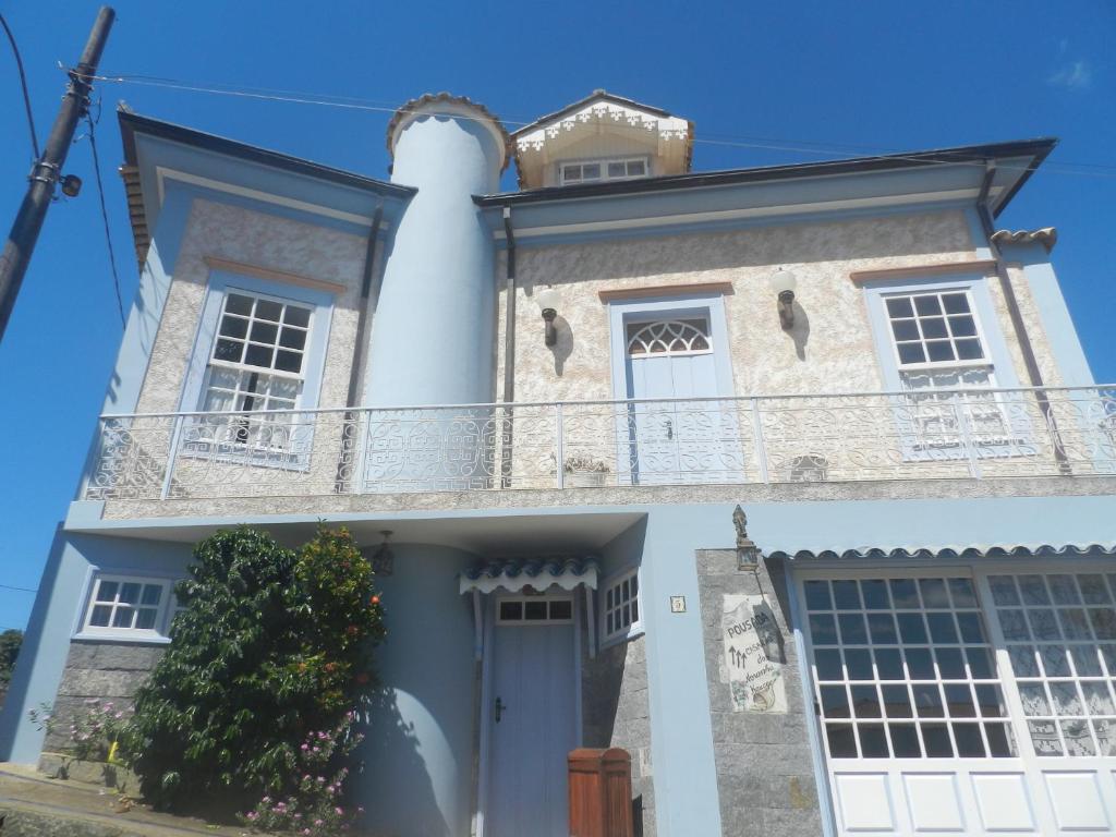 a white house with a balcony on top of it at POUSADA CASARÃO NORONHA KAUAGE in Cristina