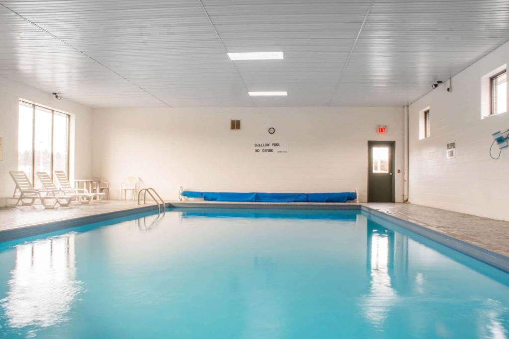 a swimming pool with blue water in a building at Quality Inn in Bracebridge