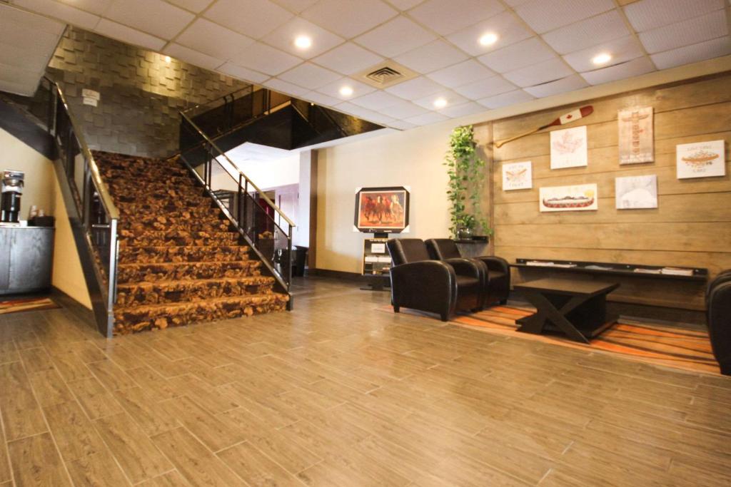 a lobby with chairs and a staircase in a building at Quality Inn in Bracebridge