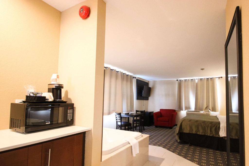 a hotel room with a bed and a microwave at Quality Inn in Bracebridge
