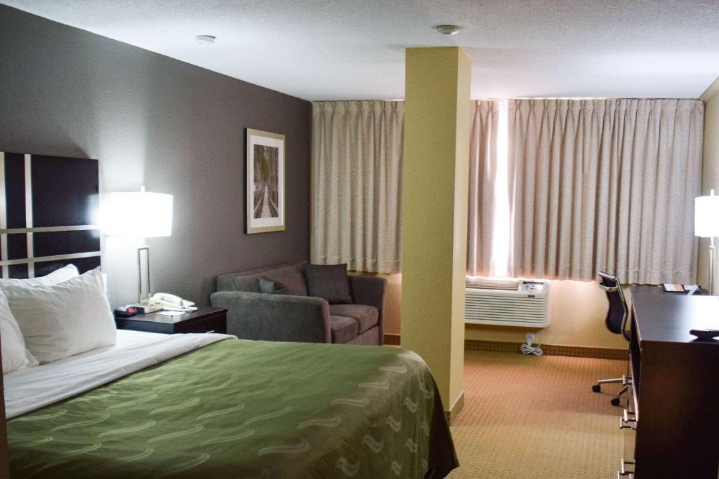 a hotel room with a bed and a chair and a desk at Quality Inn in Bracebridge