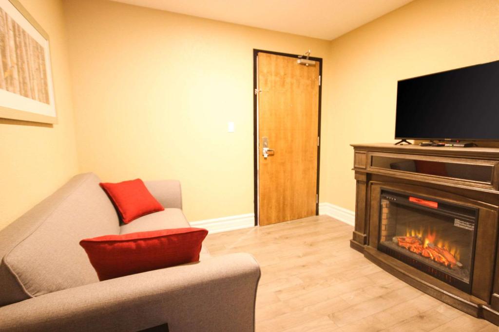 a living room with a fireplace and a television at Quality Inn in Bracebridge