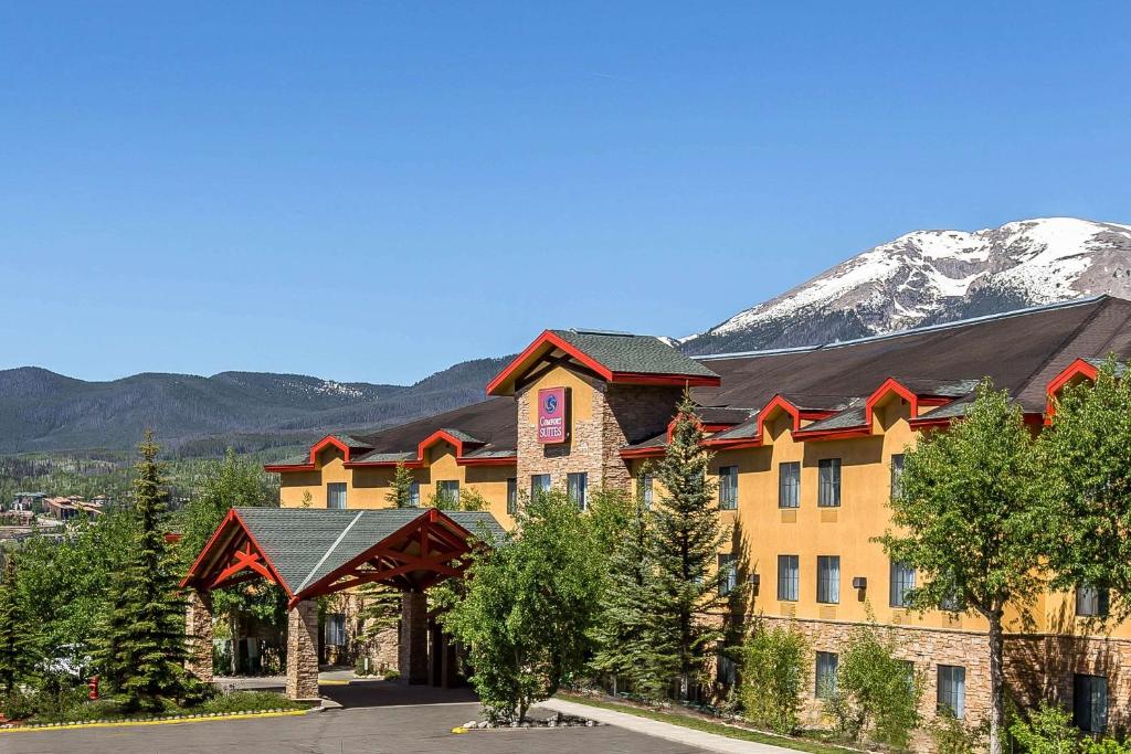 a resort building with a mountain in the background at Comfort Suites Summit County in Dillon