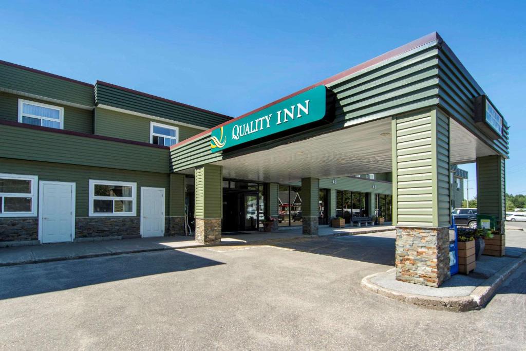 un edificio con una señal para una posada de calidad en Quality Inn Bracebridge en Bracebridge