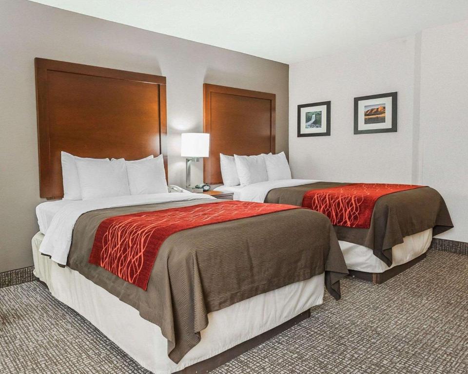 um quarto de hotel com duas camas com cobertores vermelhos em Comfort Inn Denver East em Denver