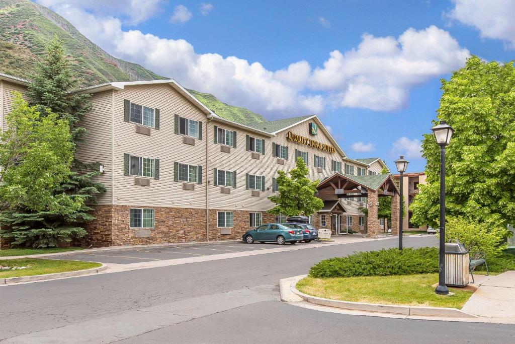 a building with a car parked in front of a street at Quality Inn & Suites On The River in Glenwood Springs