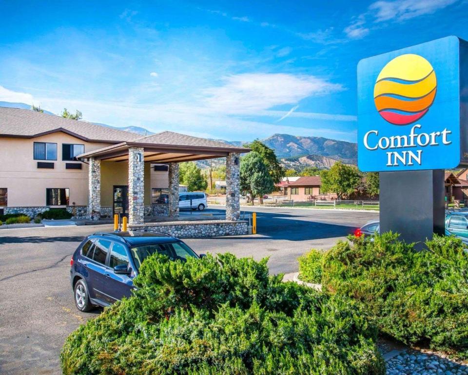 a sign for a comfort inn with a car parked in a parking lot at Comfort Inn Salida in Salida