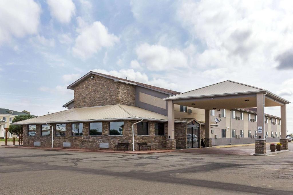 un grand bâtiment en briques avec un parking dans l'établissement Quality Inn, à Lamar