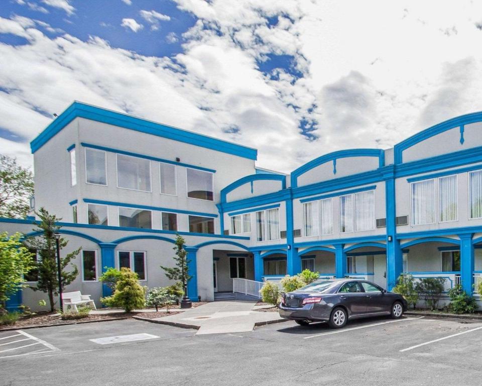 un edificio azul y blanco con un coche aparcado en un aparcamiento en Econo Lodge Inn & Suites Old Saybrook - Westbrook, en Old Saybrook