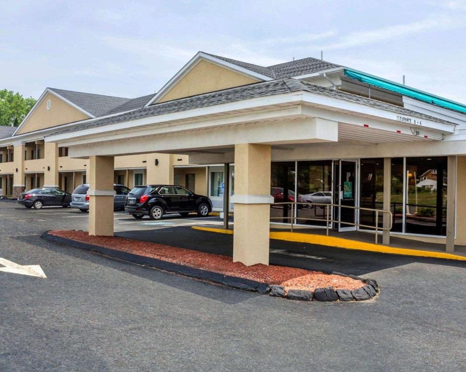 ein Gebäude mit Autos auf einem Parkplatz in der Unterkunft Quality Inn Waterbury in Waterbury