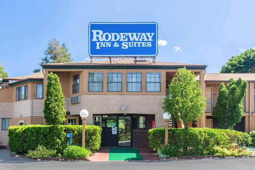 a rodeway inn and suites sign on top of a building at Rodeway Inn & Suites Branford - Guilford in Branford
