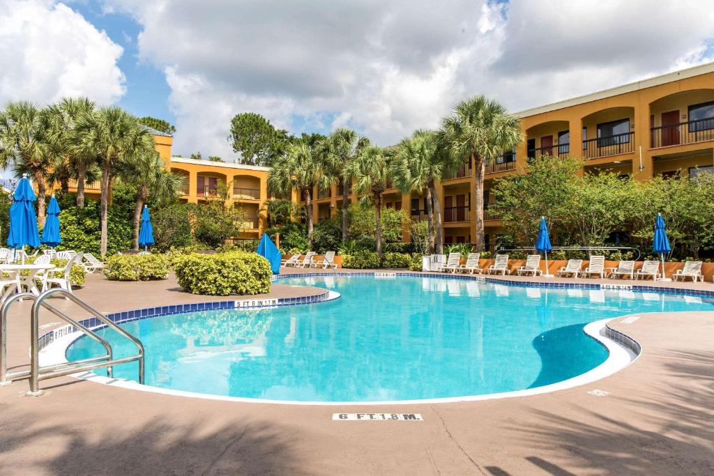 a swimming pool with a pool table and chairs at Mi Casa Hotels in Orlando