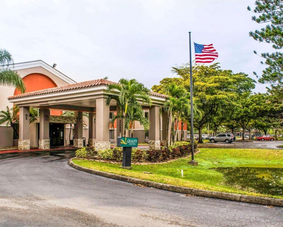 Um edifício com uma bandeira americana à frente. em Quality Suites Fort Myers Airport I-75 em Fort Myers