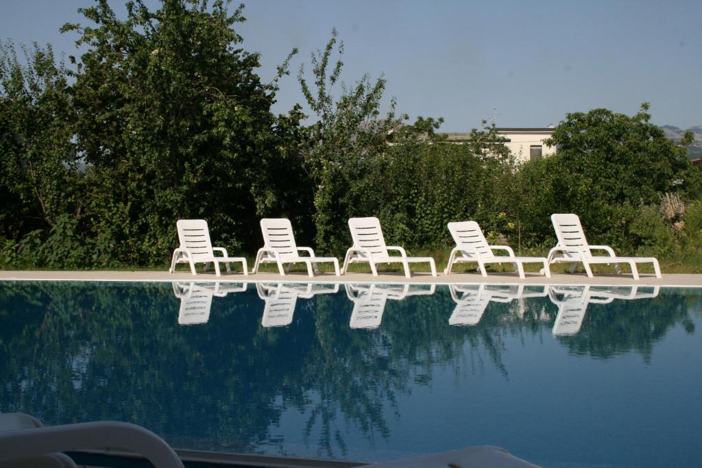 a group of lawn chairs sitting next to a swimming pool at Hotel Residence Turium in Santa Maria del Cedro