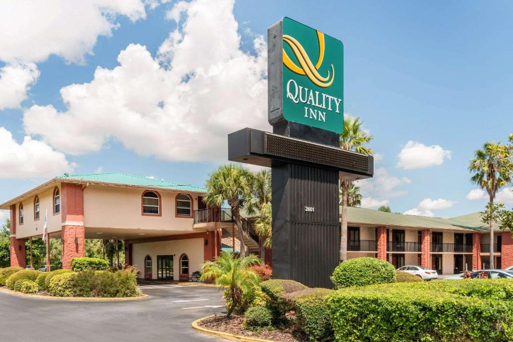 um sinal para uma estalagem de qualidade em frente a um edifício em Quality Inn & Suites Orlando Airport em Orlando