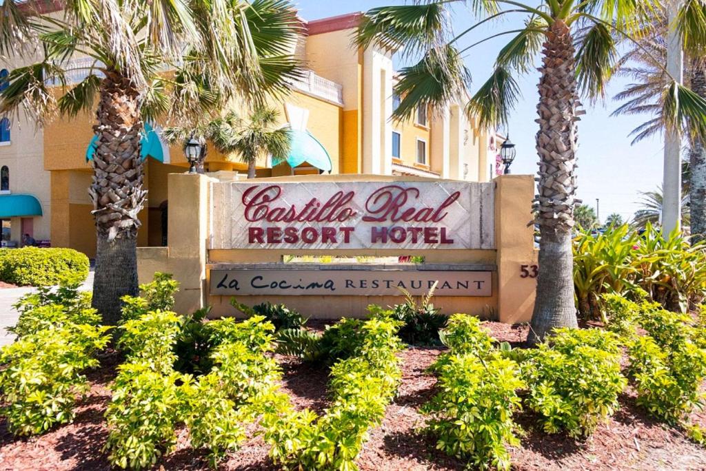 a sign in front of a resort hotel with palm trees at Castillo Real, Ascend Hotel Collection in Saint Augustine Beach